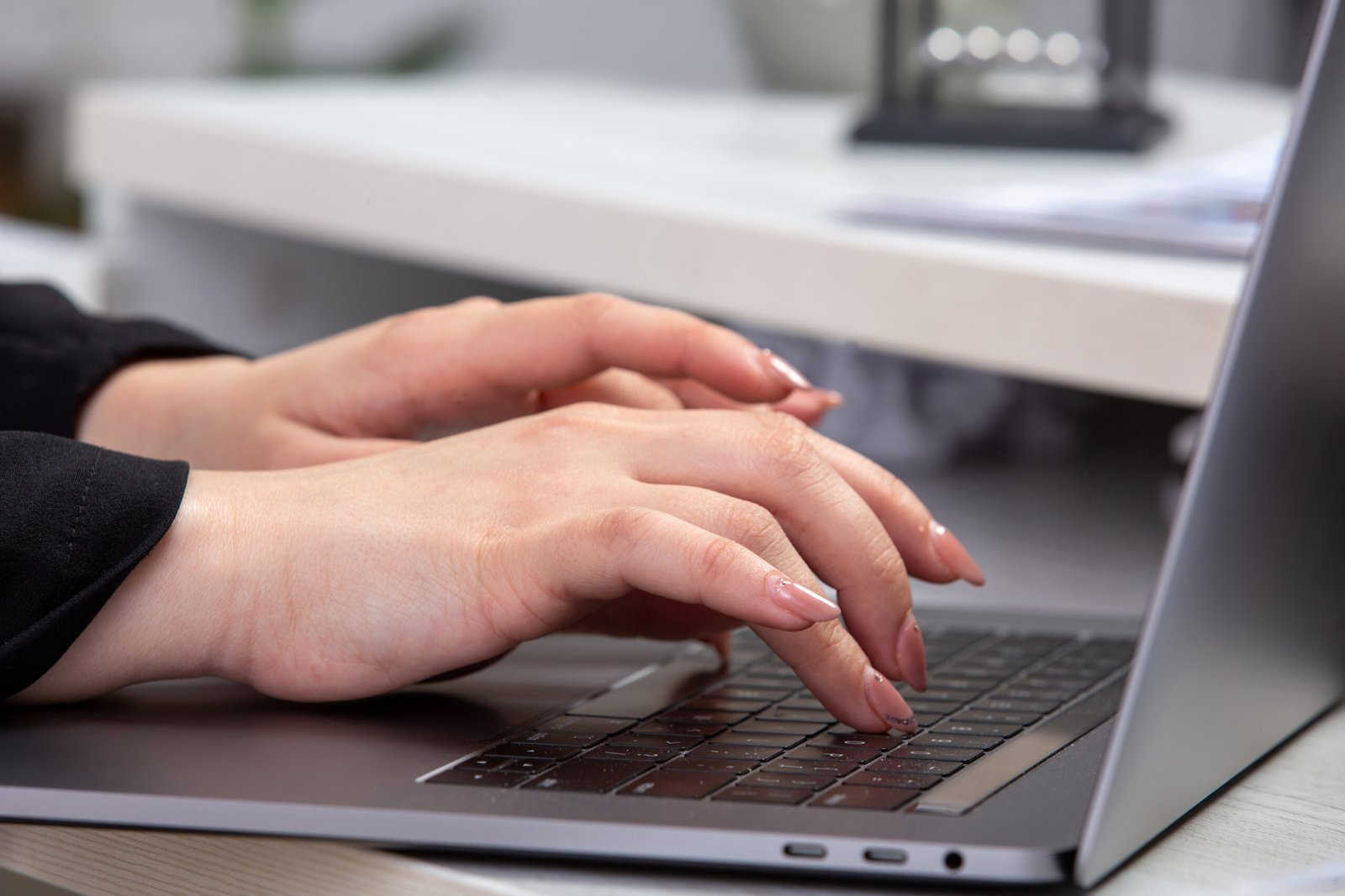 Mão feminina digitando no computador em um escritório. Representando o que é assessment