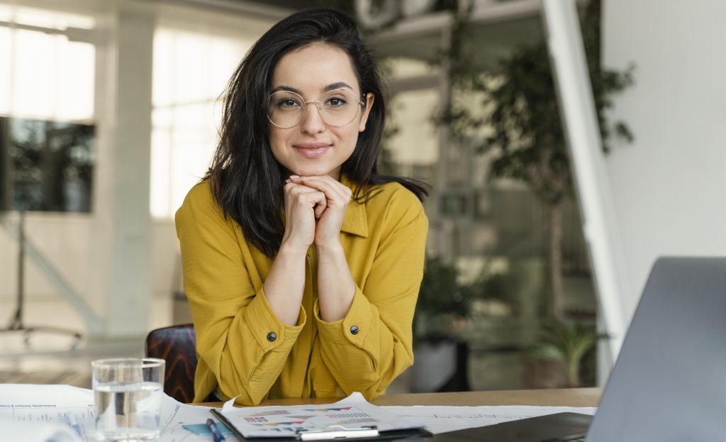 na imagem tem uma mulher em um escritório digitando no computador em um escritório. Representando o que é inteligência emocional
